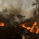 Debris burns behind a structure during the Bond Fire near Lake Forest, California on Dec. 3, 2020.